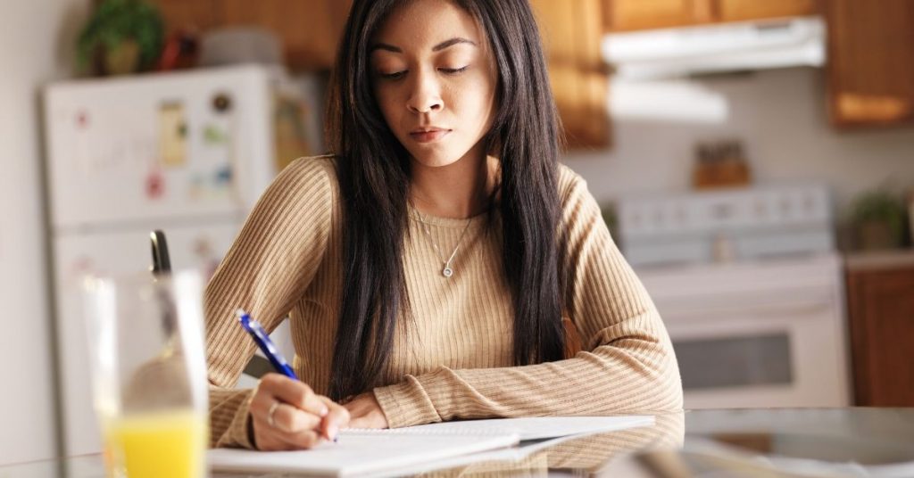 photo of a girl studying at the dining table at home
