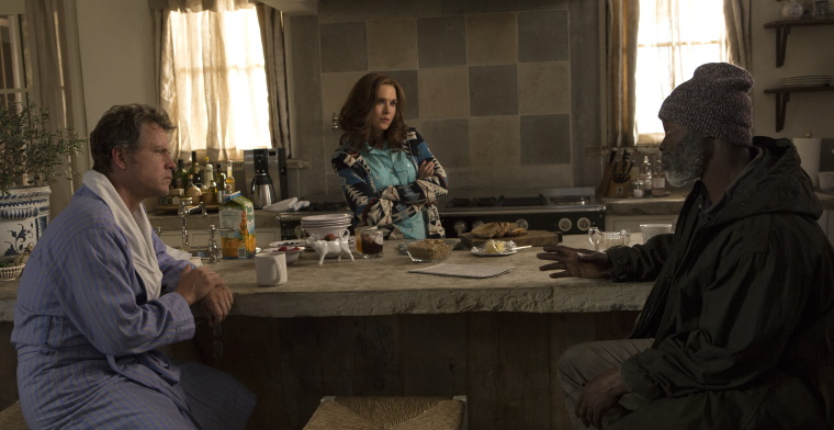 A film still of Ron, Debbie and Denver talking around a table